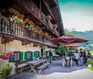 Gäste vor Berg und Bauernhaus